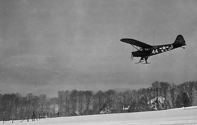 « Aérodrome de La Platte » : Un Piper Cub en phase d’atterrissage. En arrière-plan, les tilleuls de la route du Tonnelet et la villa Bel Air