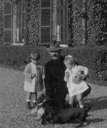 Devant la façade principale du château du Haut-Neubois.  Le garde-chasse Charlemagne Gernay avec des enfants de la famille Peltzer.